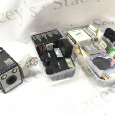 A collection of camera accessories including lenses, filters , grips, flashlights and a Brownie Flash 2 Camera . Postage category C