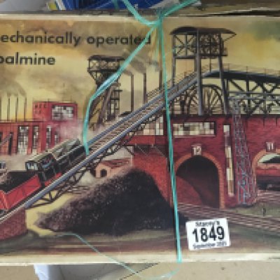 A boxed tin plate toy in the form of a coal mine .
