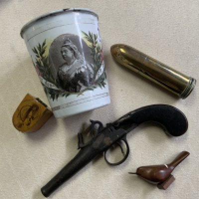 A Victorian enamel coronation beaker, Brass trench art lighter, Mauchline ware thimble case, Salla carved bird figure, early flintlock pistol in poor condition.