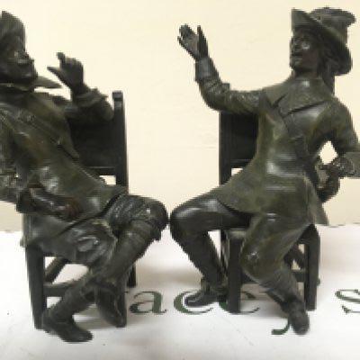A pair of bronzed metal figures of seated cavaliers the chair rail stamped Geo Maxim (2) Height 26cm one leg damaged.- NO RESERVE