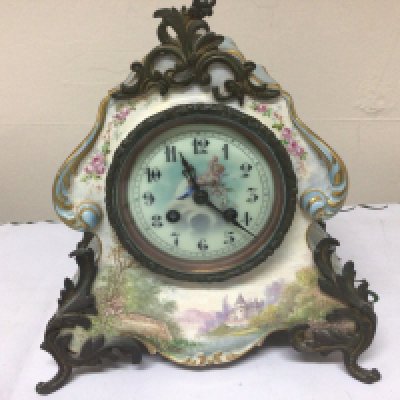 A French Early 20th Century porcelain clock painting with a view of a chateau with metal mounts. With one side ornament. Height