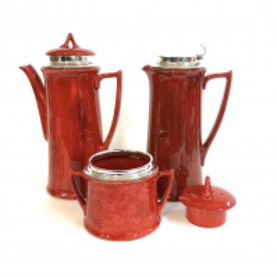 A silver mounted Royal Doulton Flambe Coffee pot, Water Jug, Sugar pot each with hallmarked silver rims.