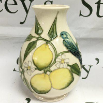 A Moorcroft vase in Lemons pawn, approx height 19cm and a conforming Moorcroft plate, approx diameter 25.5cm. Shipping category D.