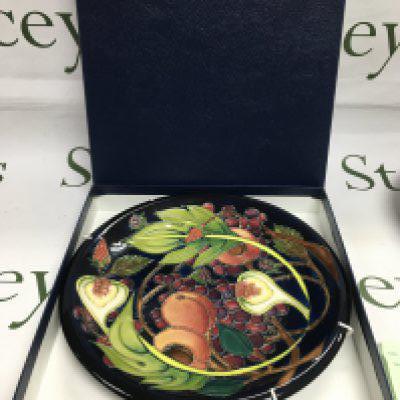 A boxed Moorcroft plate in Queen's Choice pattern, approx diameter 26cm. Shipping category D.
