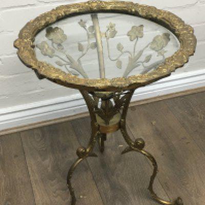 A small heavy brass glass topped table with leaf decoration. 53cm tall 39cm wide
