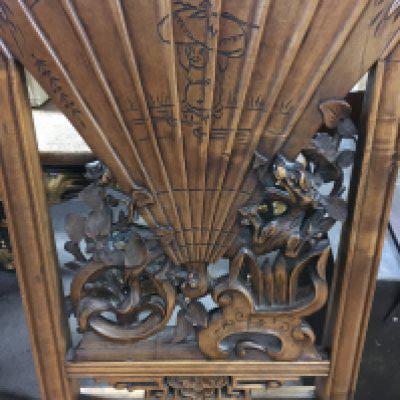 A Chinese chair the backed carved with dragons flowers and a fan above a drop in seat on scrolled Legs .