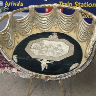 This is a gilt, neoclassical-style chair with a dark velvet cushion and putti details. 70cm tall 67cm wide