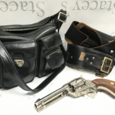 A replica blank firing MGG maker colt revolver in a leather holster