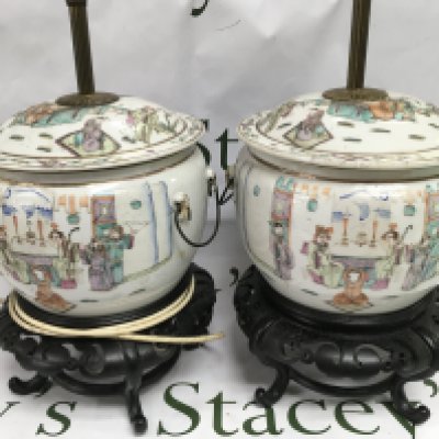 A pair of hand painted Oriental ceramic lamps raised on carved hardwood stands. Shipping category D.