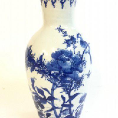 A Chinese blue and white porcelain vase depicting a bird perched on flowering plants (rim of vase damaged with chip and hairline crack and crack at base) 25cm tall.