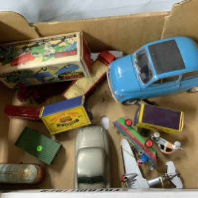 A mixture of vintage toys and vehicles, including a chrome plated tin Streamliner made by Schylling which is a wind up, a scale model wind up toy made by Minic, 2 vehicles from the matchbox series, a dinky toy and some other vintage vehicles.