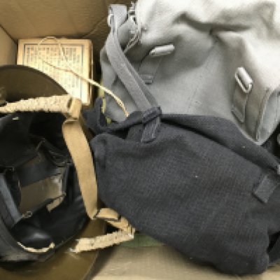A Collection of WW1 & 2 items including a children&rsquo;s gas mask, a soldiers helmet and various bags.