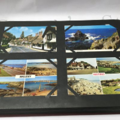 A postcard album with a number of vintage postcards. Postage B