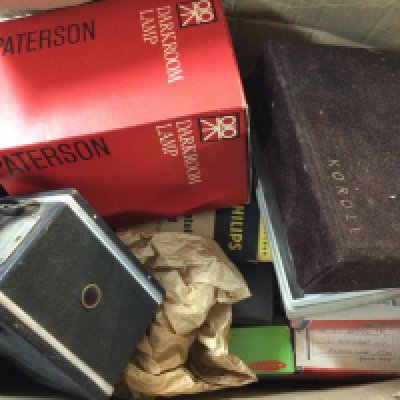 A collection of cameras, one is a vintage box camera and the other is a camera by Koroll and a collection of colour slides and also includes a Phillips light bulb.