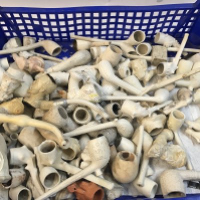 A Collection of clay pipes with faces of historical figures.