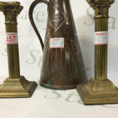 An antique pair of vintage brass candlesticks and a copper antique jug made in the 1900s in Britain.