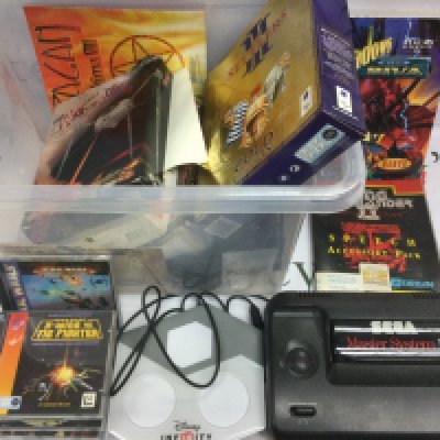 A Sega Master System II power base and a collection of PC games.