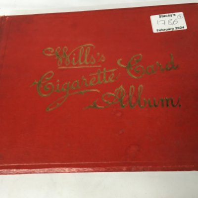 A collection of used cigarette card books, 2, and a used USA stamp album. Also, there is a Batman automobilia small book which doesn&rsquo;t include the car. Also, a semi-automatic gas pistol which is an Airsoft gun, made in Taiwan.