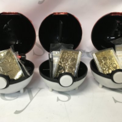 A collection of 4 poke balls and 3 23k gold plated 1999 Pok&eacute;mon cards. The cards are 2 Mewtos and Pickachu.