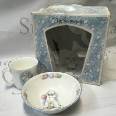 A collection of antique plates, dishes and more including the Snowman from Royal Doulton, a vintage silver plated metal teddy bear, a silver plated Humpty Dumpty, a silver plated puff puff engine bank, and a Rupert set.