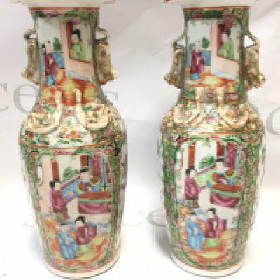 A pair of 19th century Chinese Cantonese Famille Rose vases decorated with Chinese figures. 26cm tall. Chip seen at the top of one of the vases