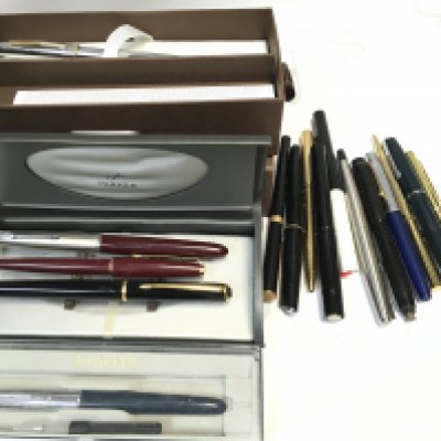 A collection of fountain pens as well as Parker pens and a cross pen.