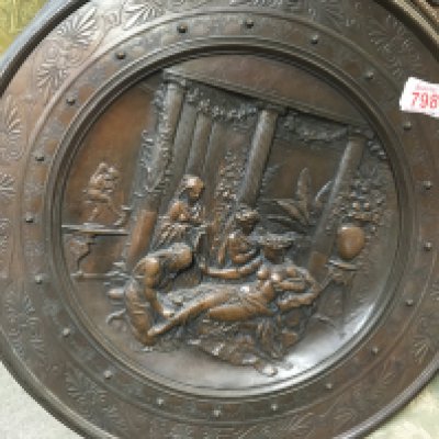 Two circular bronze plaques, one depicting an Ancient Greek scene and the other depicting a scene from ancient Egypt. The approximate diameter of each is 50cm. Also, there is a larger gold-coloured plaque.