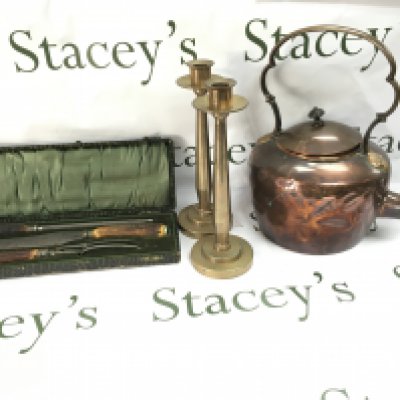 A copper kettle pair of heavy candlestick holders and a cased carving set.
