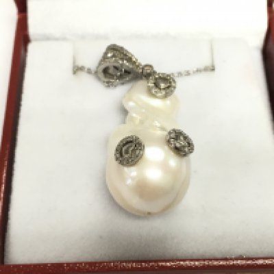 An unusual silver baroque pearl and diamond set pendant with heart motifs on a silver chain. Pearl 40.95ct and diamonds 0.32ct Approx.