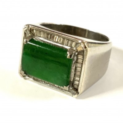 A heavy 18ct white gold ring set with a large polished green jade stone surrounded by baguette diamonds. 10.3g, Size O (A)