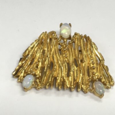 An unmarked gold brooch set with three opal stones. Approximately 4cm wide and 16.20g