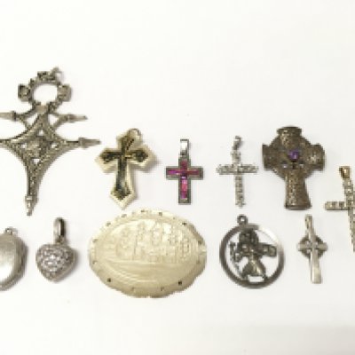 a collection of pendants including mother of pearl, some silver examples and a 9 ct gold cross pendant inset with diamond stones (2.7g total weight) .
