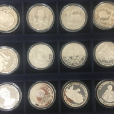 A collection of silver proof and other coins thirty two mixed commemorative coins all in plastic capsules.