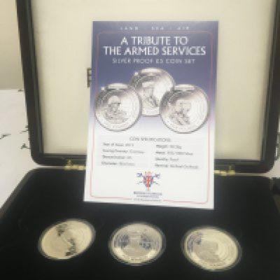 A cased Silver Proof five pound coin set A Tribute to the Armed Services. Three silver coins with certificates of authenticity.