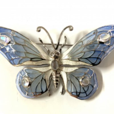 A sterling silver butterfly brooch set with moonstone and pliqe au jour enamel.
