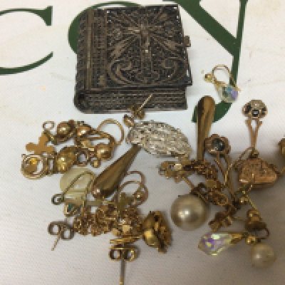A collection of gold and other earrings a white metal filigree book box containing a rosary beads and other oddments.