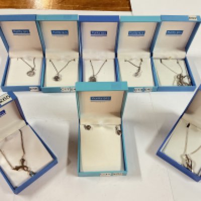 a collection of mixed silver chains and pendants as well as a silver clasped pearl bracelet.