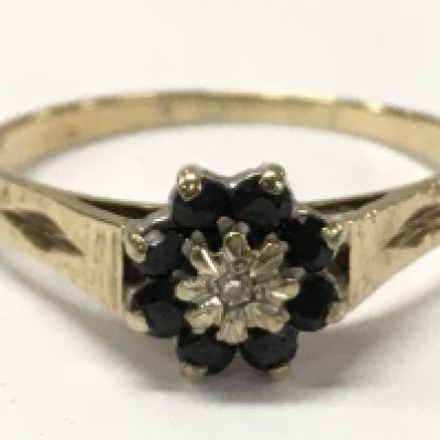 A 9ct gold flower pattern sapphire ring set with a central small diamond stone , size W. 2.5g total weight. Postage category A