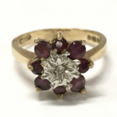 A 9ct gold ring set with a pattern of ruby and chip diamonds , 3.1g total weight. Size M. Postage category A