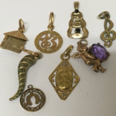 A collection of gold charms and pendents. Weight 8g