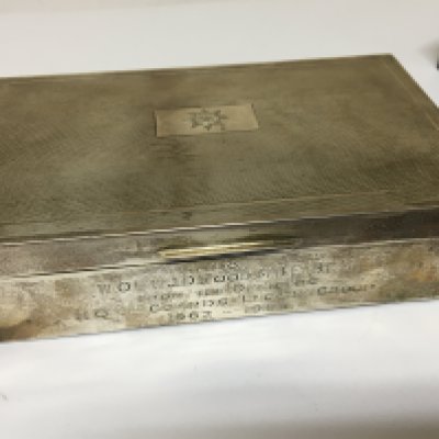A silver cigarette box of rectangular shape with personal inscription.