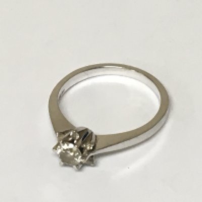 An 18carat gold ring set with a brilliant cut diamond approximately 0.3 flanked by smaller diamonds of a carat ring size P. Weight 3.7g