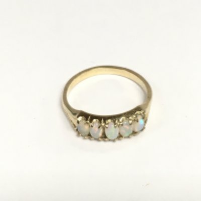 An unmarked gold ring set with five opals, approx 2.8g and approx size R-S. Shipping category A.