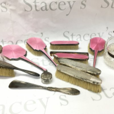 Silver hallmarked dressing table set including brushes, glass containers with silver collar, lids and a non silver pink enamel set . Postage category b