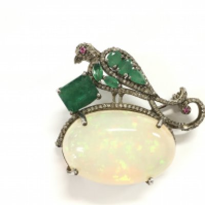 Bird of paradise brooch - pendant in silver set with a large cabochon oval opal ruby eyes and emerald and diamonds. Opal 26.18ct emeralds 3.16ct and diamonds 0.69ct all approximately.