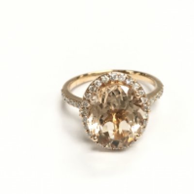 An 18ct rose gold ring set with an oval morganite surrounded by a halo of diamonds with diamond shoulders. Morganite 4.26ct and 0.49ct diamonds Approx and size P