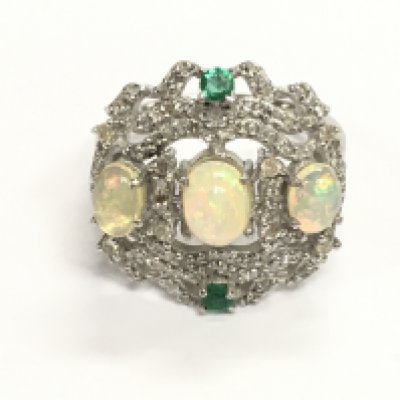 Ornate silver dress ring set with 3 oval cabochon opals 2 emeralds and diamonds. Approximately 1.80ct opal 0.15ct emerald and 0.35ct diamonds. Size P 1/2