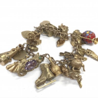 A 9ct charm bracelet with a large number of charms. 82.05g Postage B