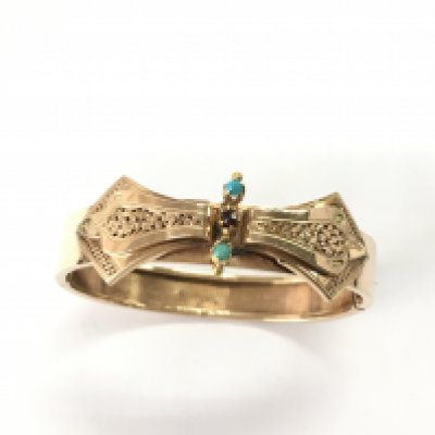 A 15ct Russian gold bangle set with garnet and turquoise. 15.39g and 6cm diameter. Postage A