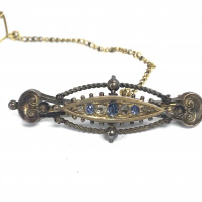 A 15ct gold brooch set with small sapphires. Has Chester hallmarks. Approximately 5cm wide and 5g